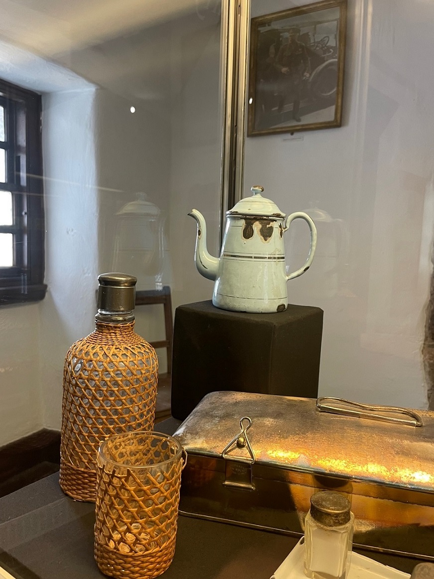 Blue enamel coffee pot displayed with other field canteen objects