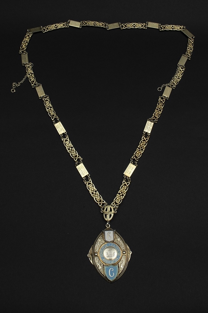 A gold chain with Celtic designs and a gold and enamel pendant