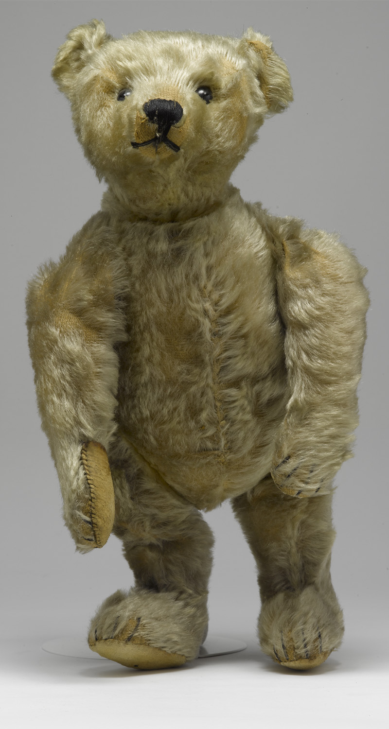 A light coloured teddy bear standing on his back legs