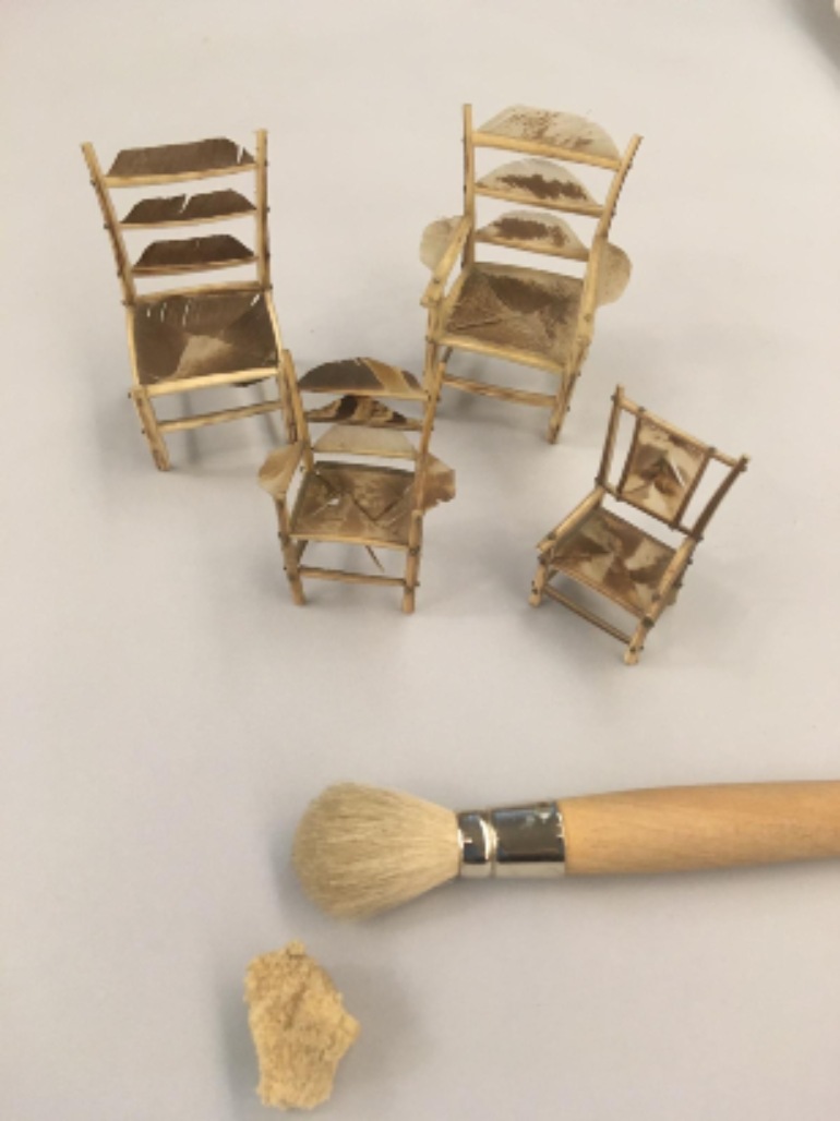 Four brown toy chairs with soft brush and sponge in the foreground