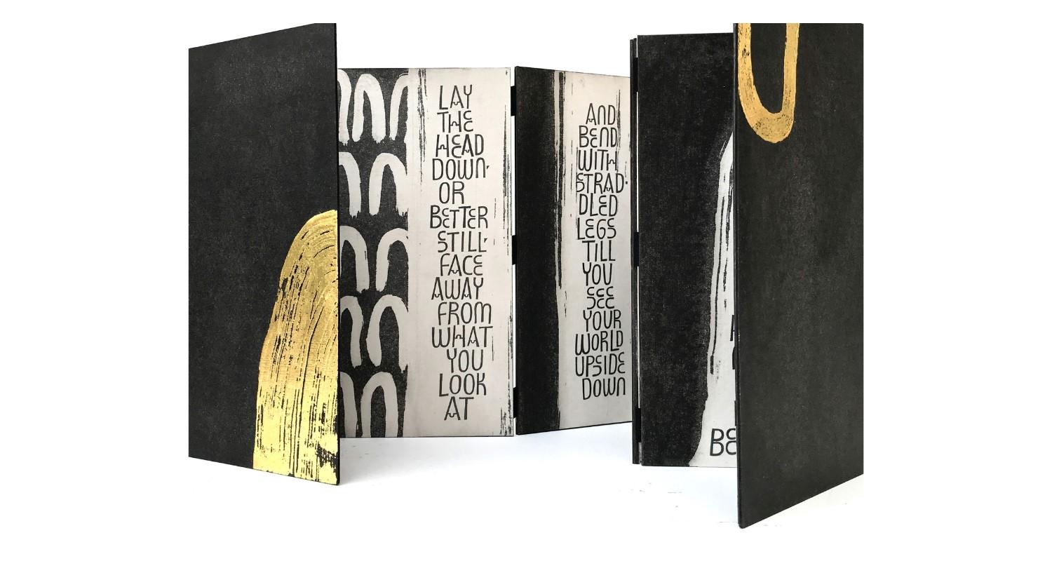 Black and gold book with text inside the cover saying in capital letters 'Lay the head down or better still face away from what you look at'.