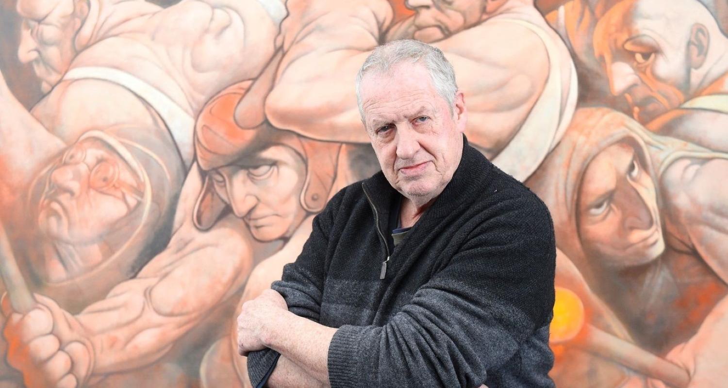 Photo of Peter Howson in his Studio in front of a painting