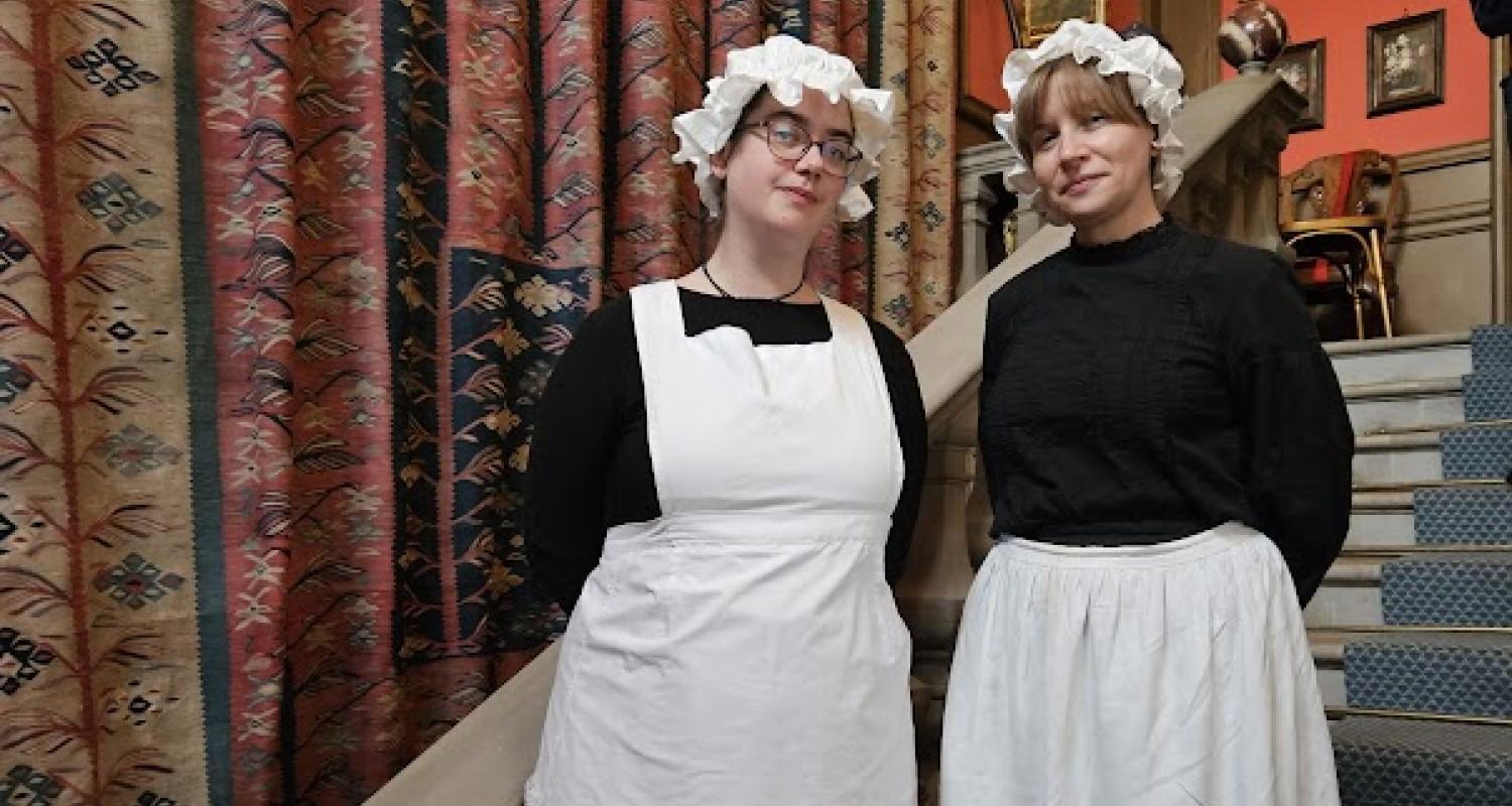 Two maids standing on the stairs at Lauriston Castle