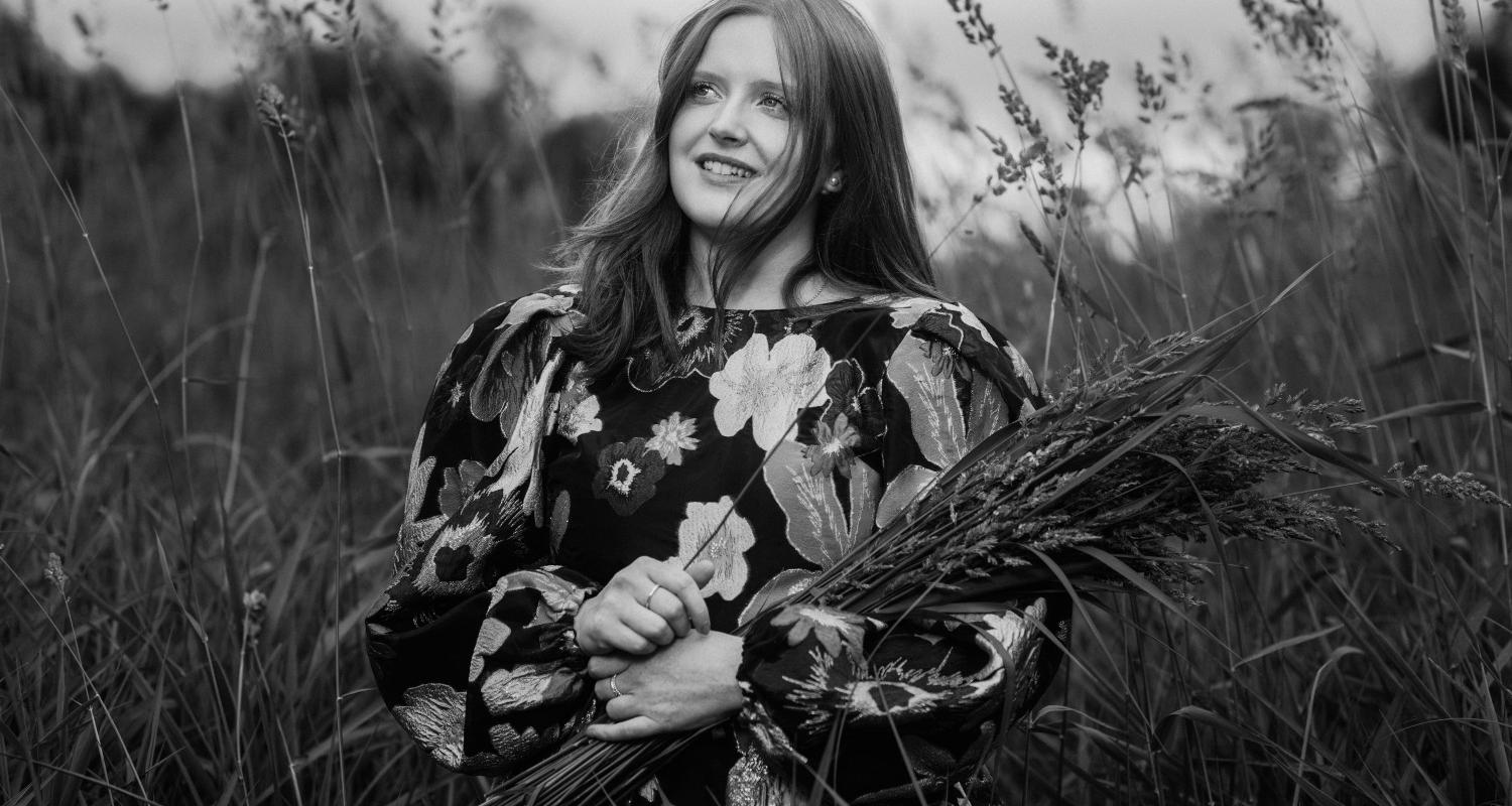 Black and white photograph of Ceitlin Lilidh in a meadow