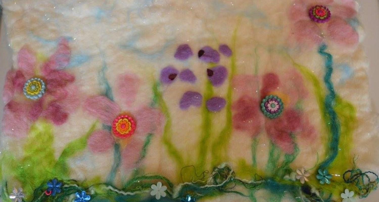 An image of felted flowers in shades of pink and purple 