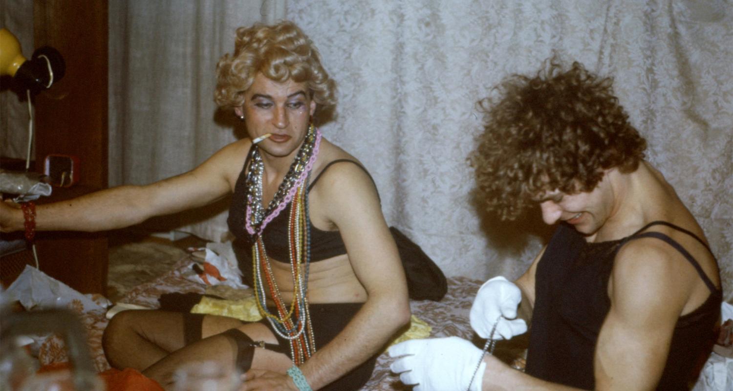 Two individuals sit together expressing their uniqueness and celebrating their queer identities