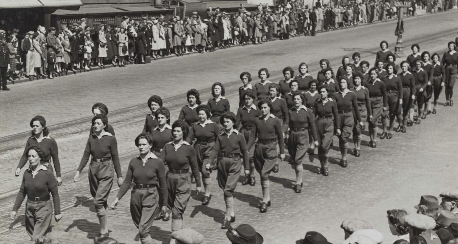 A Land Army parade in 1943. The street is lined with spectators on both sides.