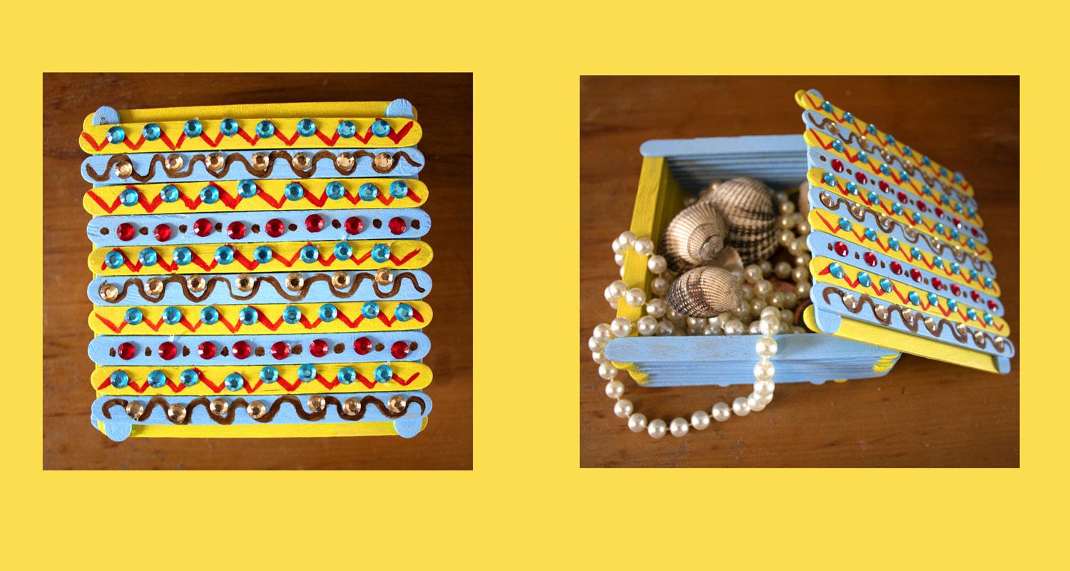 Pearls and shells inside a decorated treasure box in blue, red and yellow