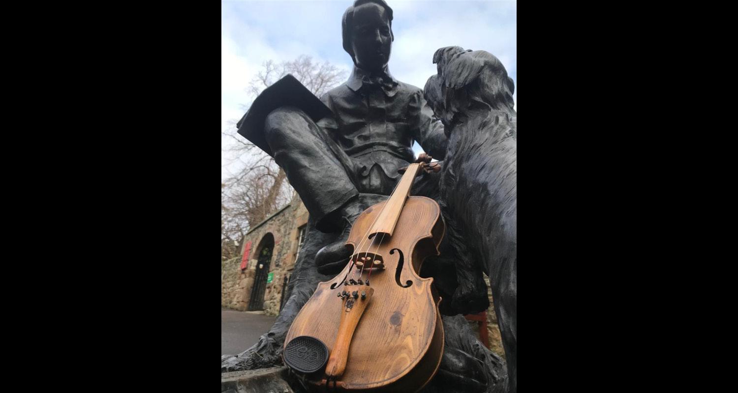 Statue of writer Robert Louis Stevenson in Edinburgh with a violin