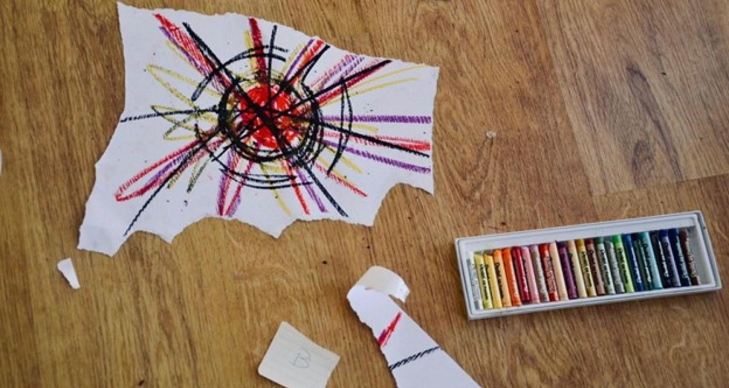 Ripped pieces of crayon-ed paper lying on a desk
