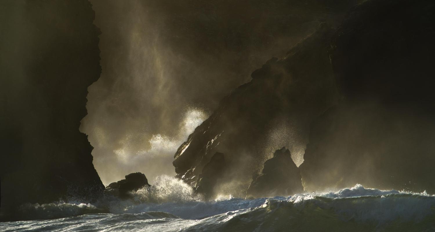 An artwork featuring wild sea and cliffs