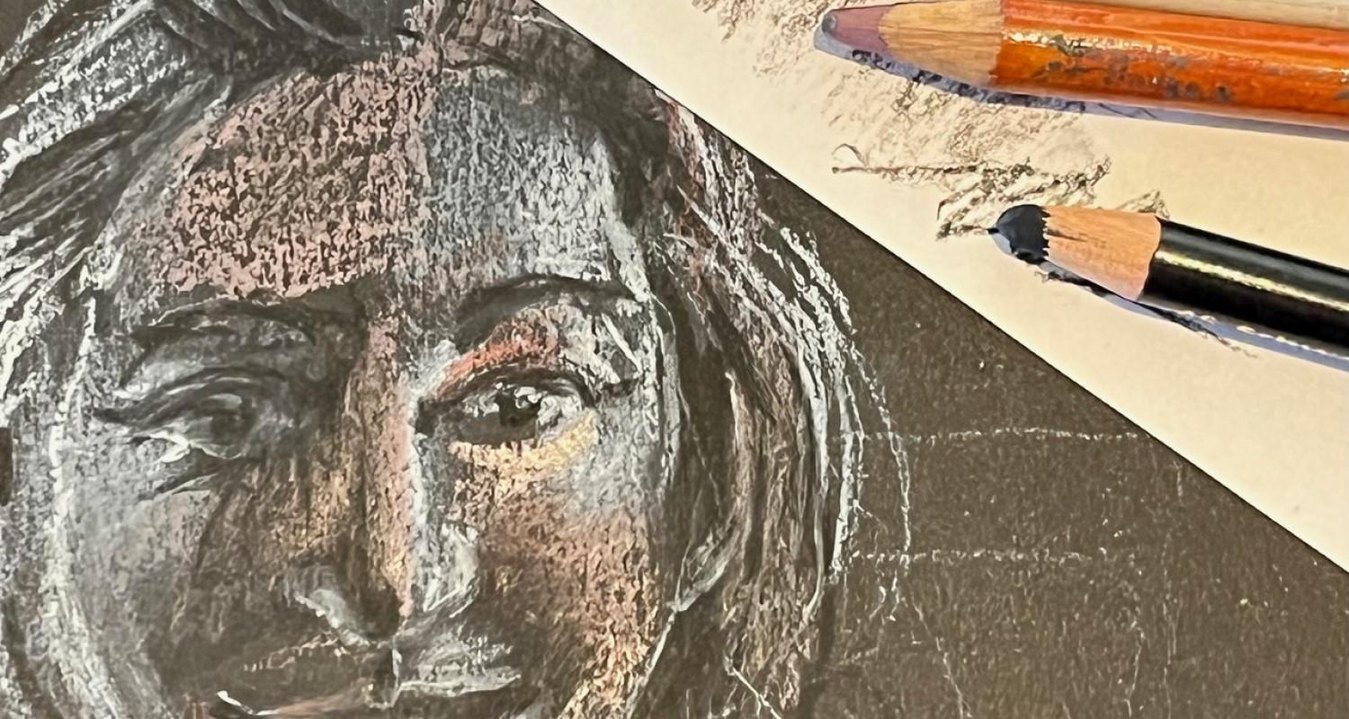 A pastel drawing of a woman on black paper, with pink and black crayons alongside