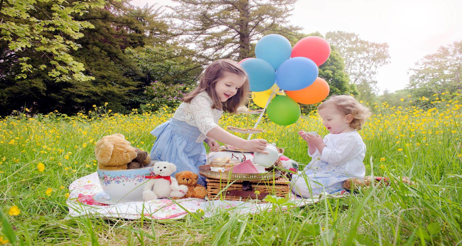 2 children having a teddy Bear's Picnic in spring gardens 