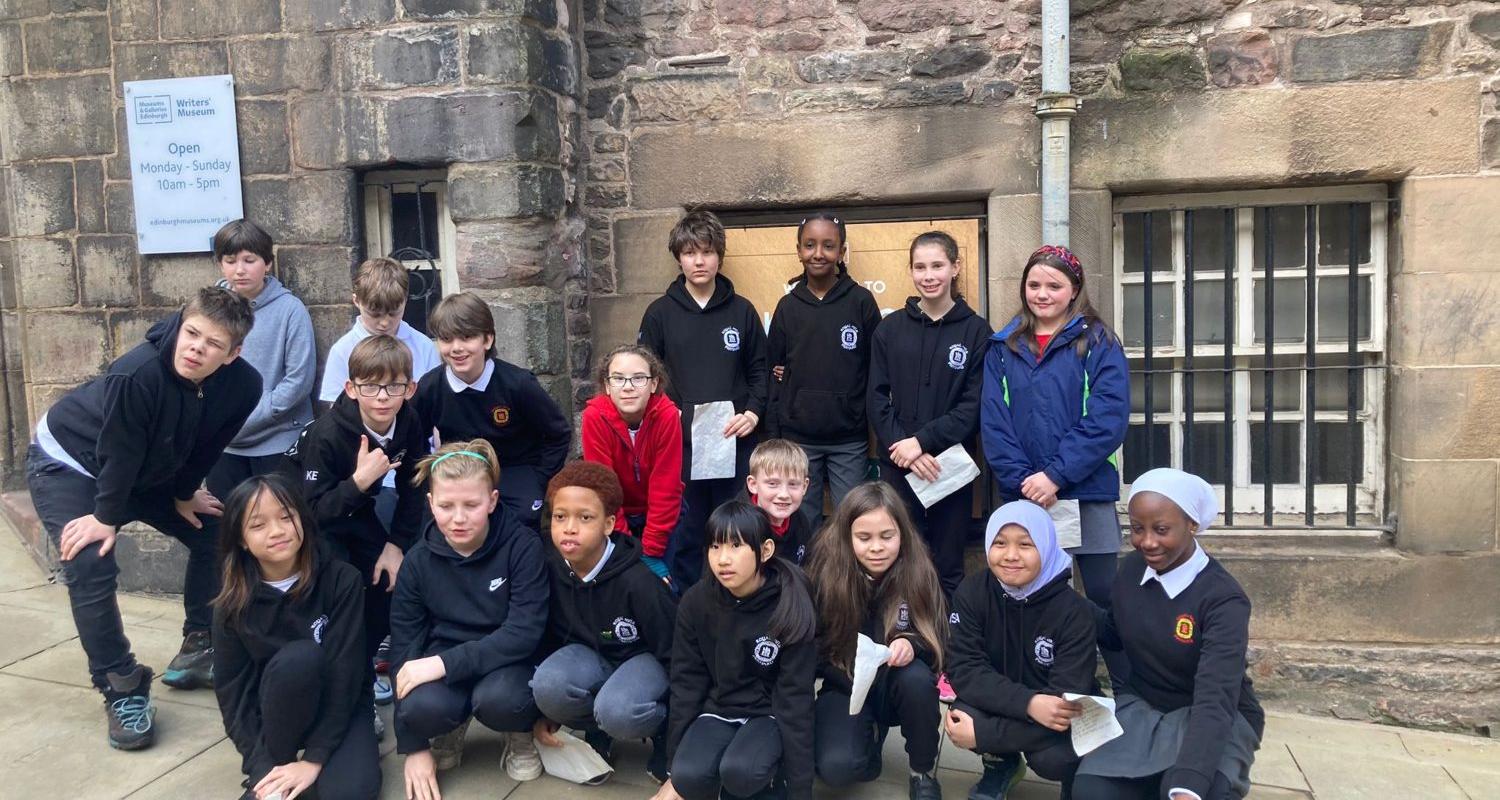 Pupils in school uniform group together in front of The Writers' Museum