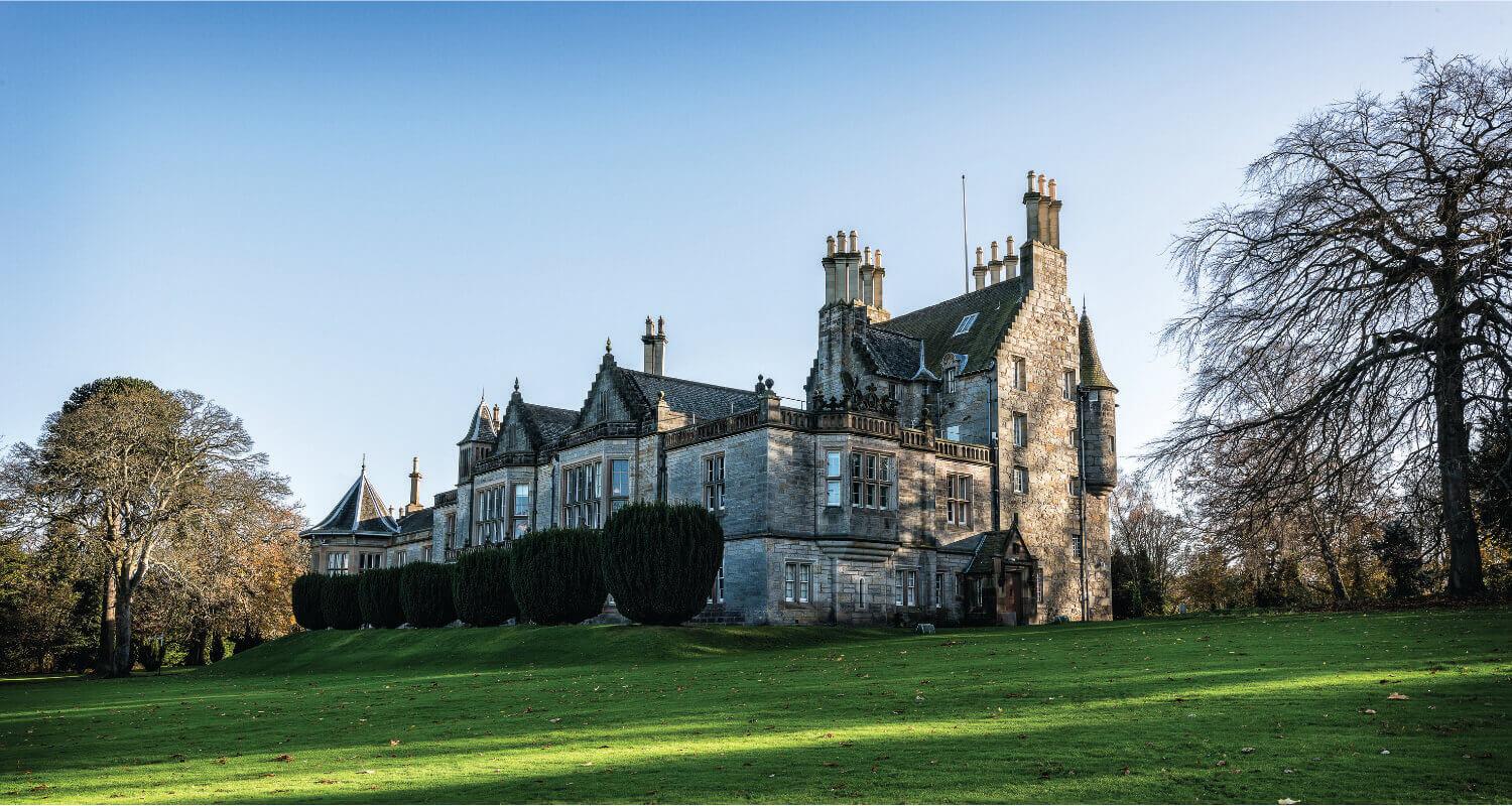 Lauriston Castle on a sunny day surrounded by trees and greenery