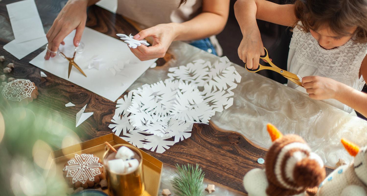 Craft table showing children making Christmas snowflakes