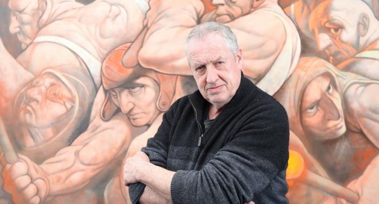 Photo of Peter Howson in his Studio in front of a painting