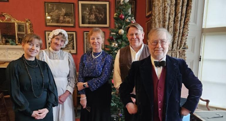 A group of costumed performers in the Castle in front of the Christmas tree