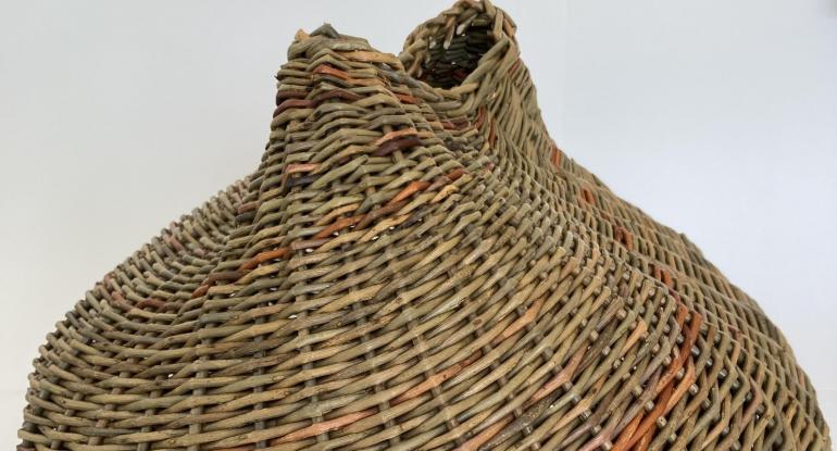 Part of a woven basket with a narrow, twisted opening