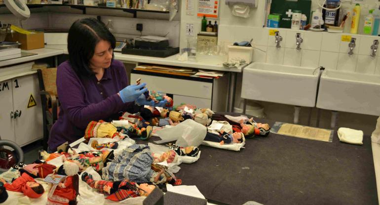 Collections Care Officer assessing costume dolls