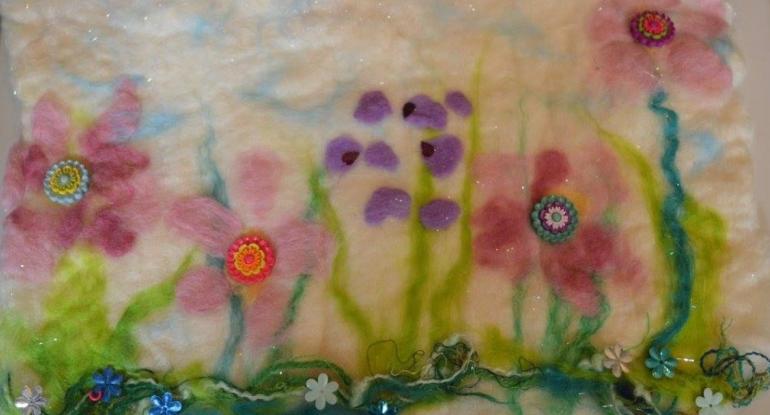 An image of felted flowers in shades of pink and purple 