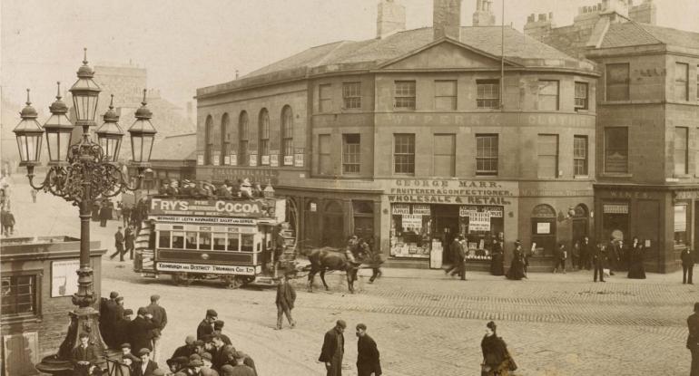Sepia Photograph, "Foot of Leith Walk". A busy street scene with horse drawn trams and old shops.