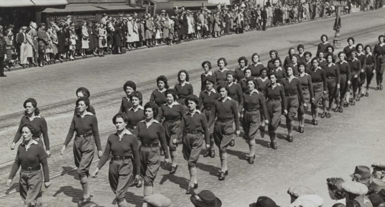 A Land Army parade in 1943. The street is lined with spectators on both sides.