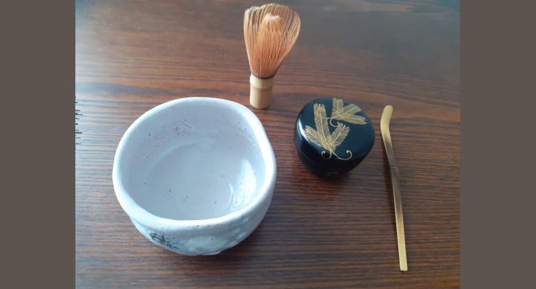 A white ceramic bowl plus the other tools used to make a cup of matcha tea