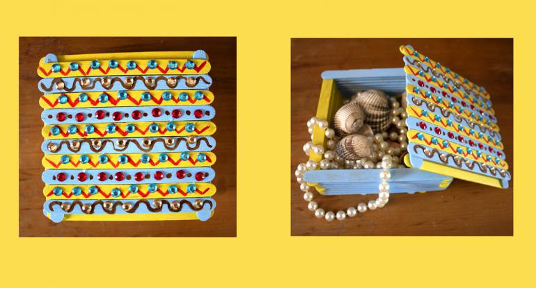 Pearls and shells inside a decorated treasure box in blue, red and yellow
