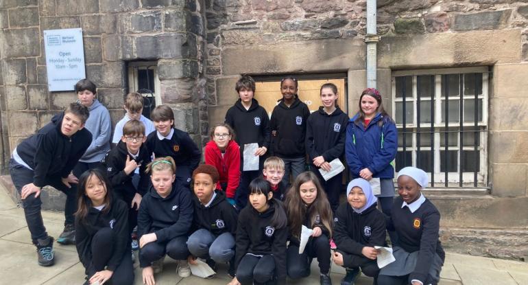 Pupils in school uniform group together in front of The Writers' Museum