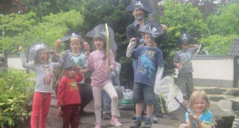 lots of children on a small island wearing pirate hats