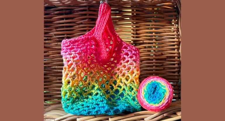 An ombre crochet bag in a wicker basket