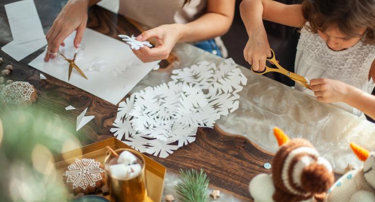 Craft table showing children making Christmas snowflakes