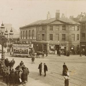 Sepia Photograph, "Foot of Leith Walk". A busy street scene with horse drawn trams and old shops.