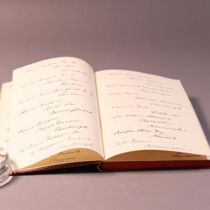 An open book with a handwritten list of contributors to Eliza Wigham's gift.