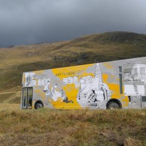 Travelling Gallery appears in the centre of the photograph with a scenic view of Scottish hills in the background 