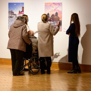 A group of people looking at a picture on a wall