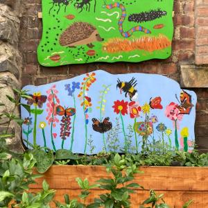 Two mural boards with images of insects and flowers and plants below them